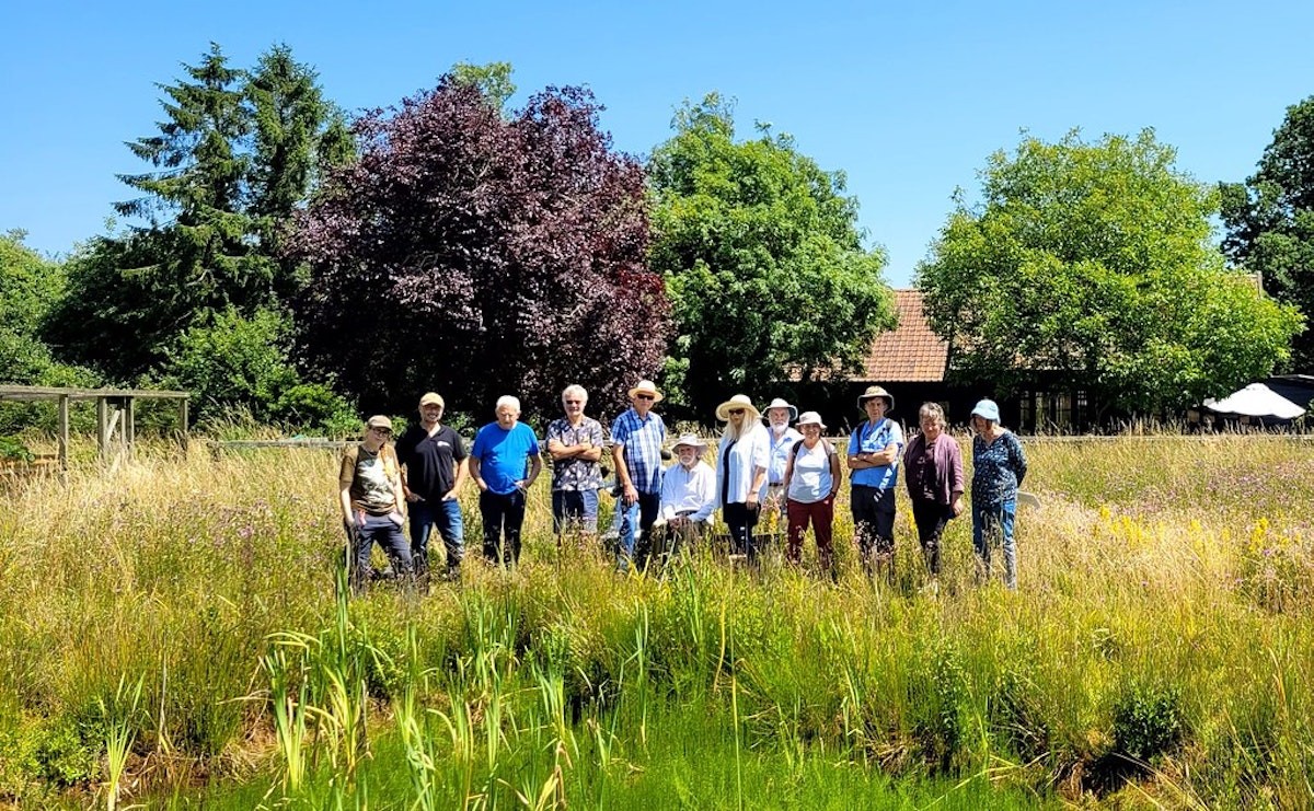 A group of people standing in a wildflower meadow at a Suffolk Wildlife Trust Private Nature Reserve event